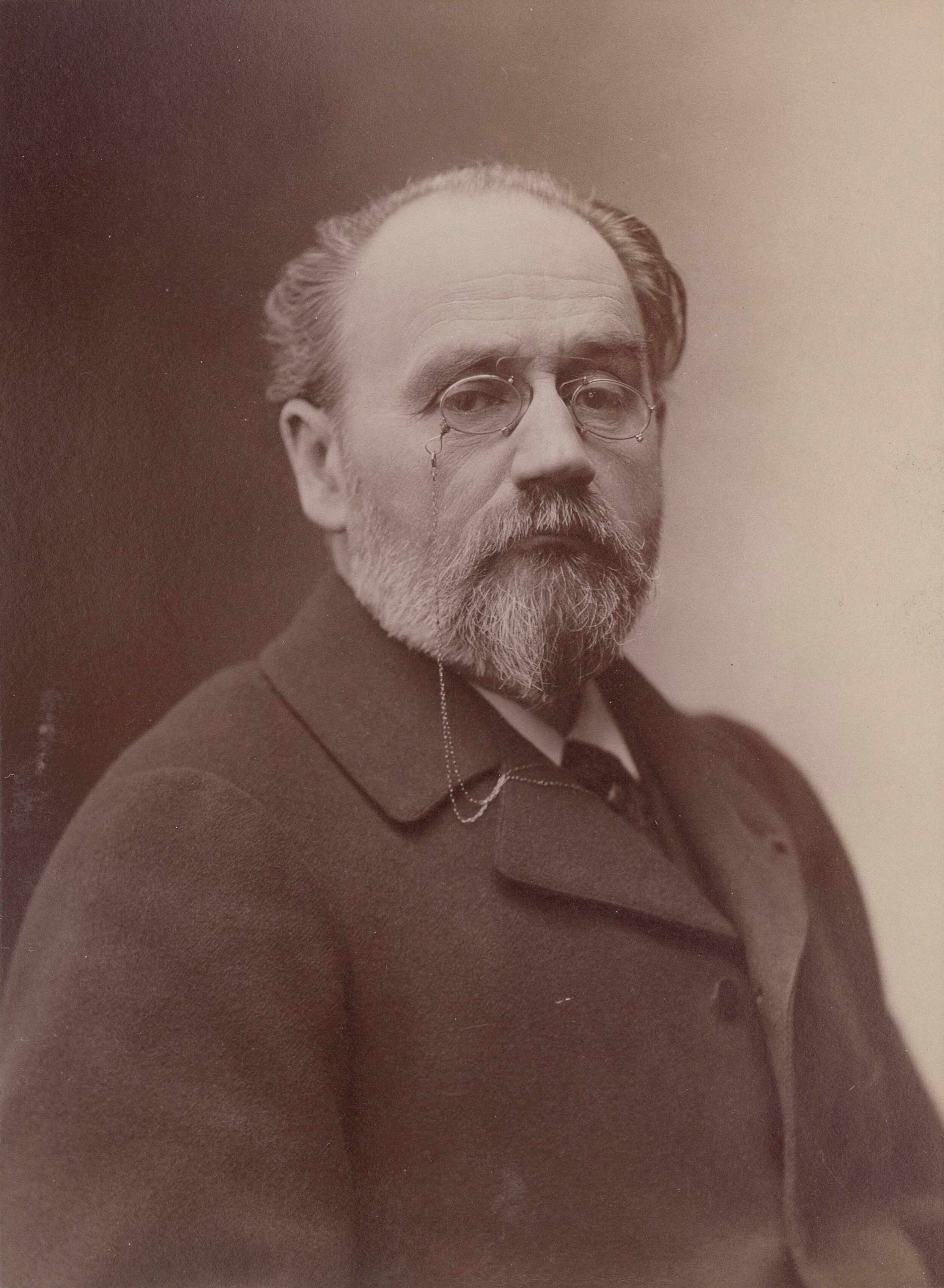 Portrait photographique en buste d'Émile Zola par l'atelier Nadar montrant le romancier avec barbe et lunettes